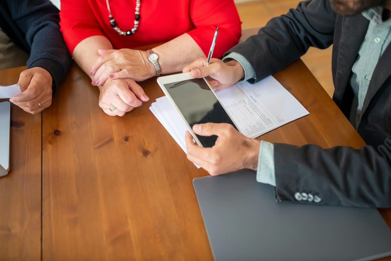Un asesor revisando documentos con clientes en una reunión