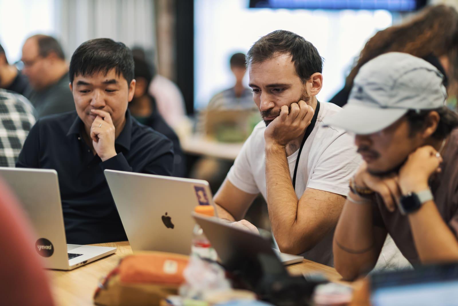 A small software team working together on laptops.
