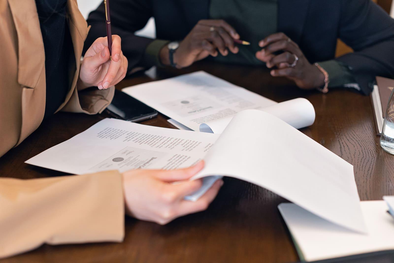 Two people reviewing printed documents together at a desk