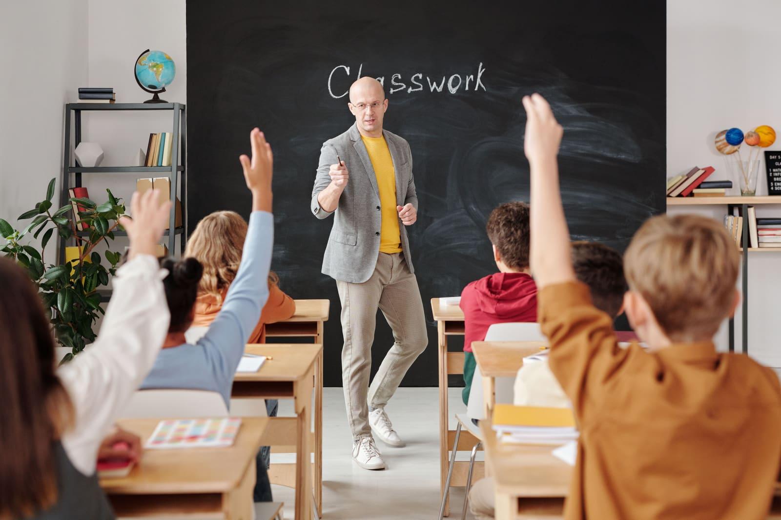 A teacher working with students in a classroom.
