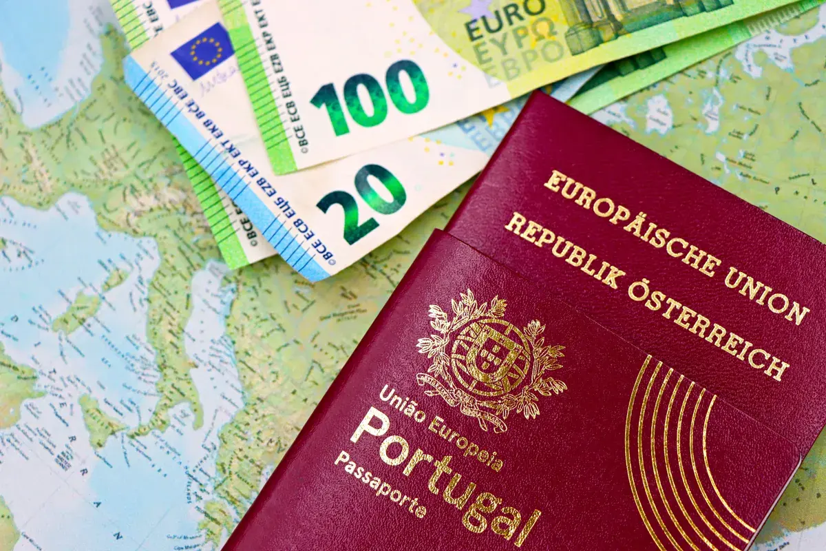 Two foreign passports arranged beside notes of currency on a world map background