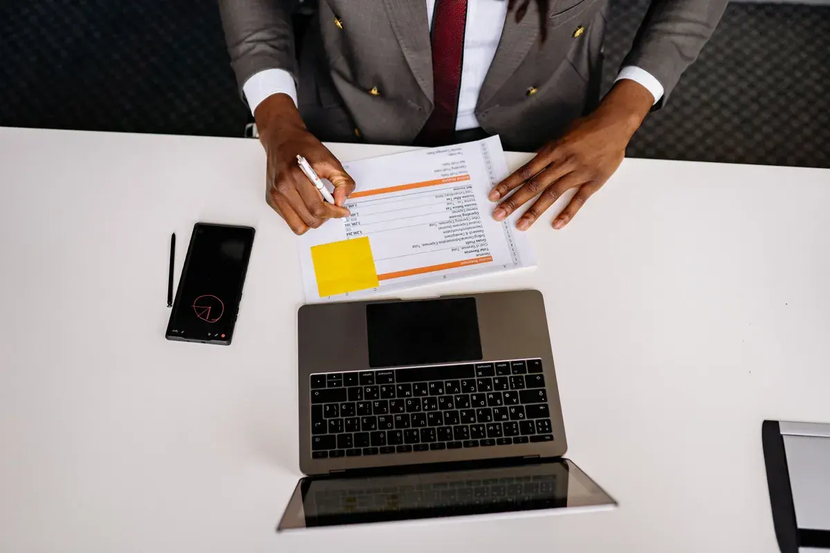 Top-down view of tax paperwork and a laptop on a clean white desk