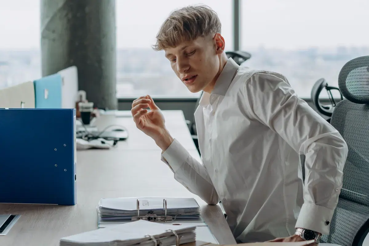 A professional at an office desk reviewing printed pages in a calm workspace
