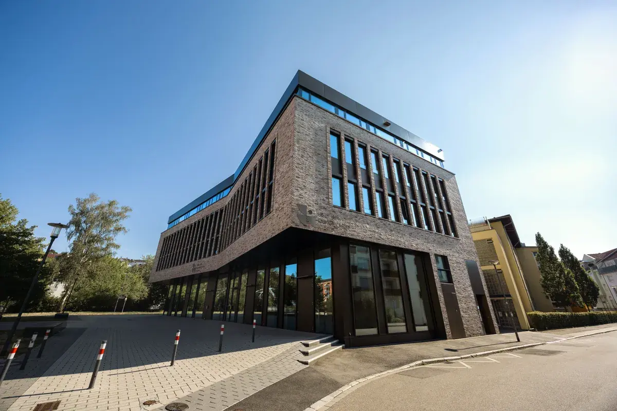 A contemporary mid-rise office building with brick and glass facade at street level
