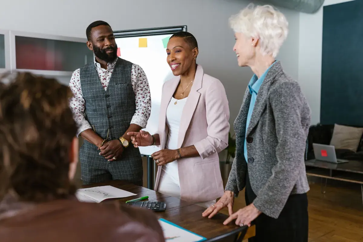 Business colleagues talking together beside a whiteboard in a bright meeting room