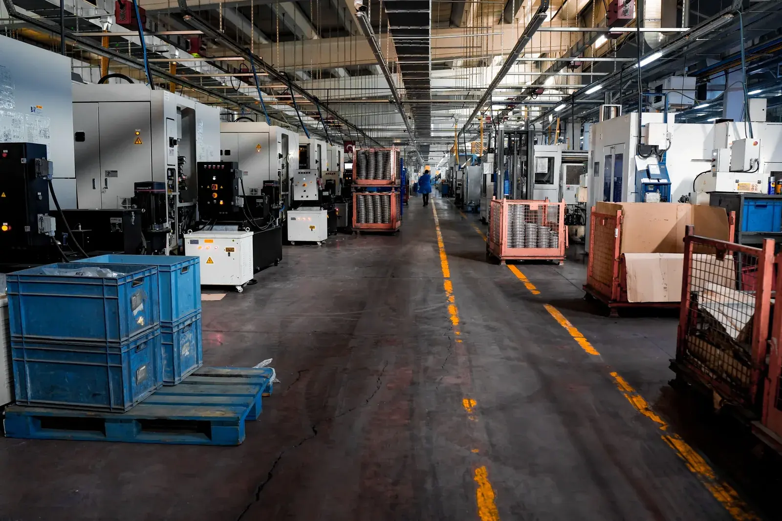 Wide interior view of a modern industrial production floor with structured workstations and equipment bays