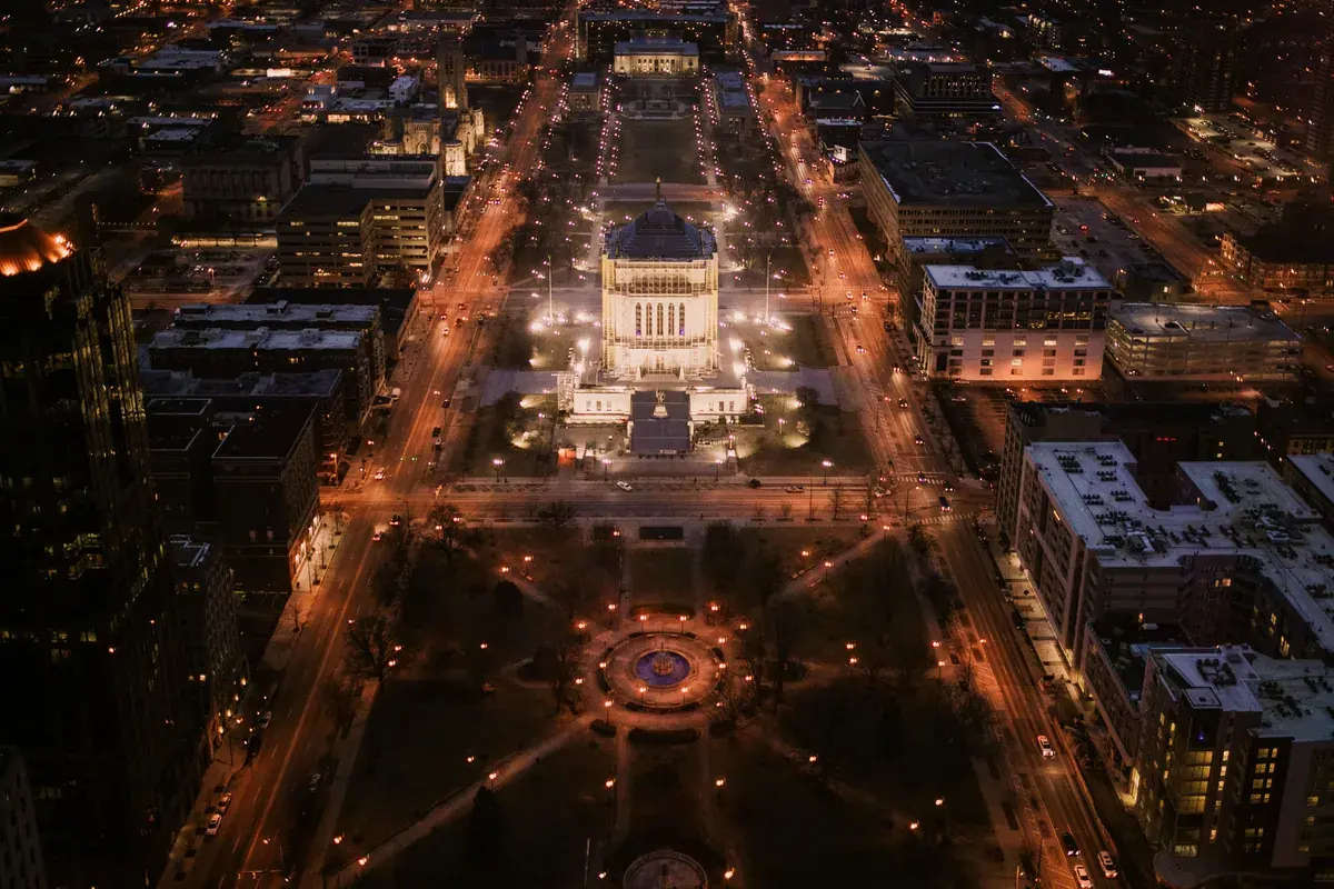 Night aerial view of a lit state capitol building surrounded by city streets