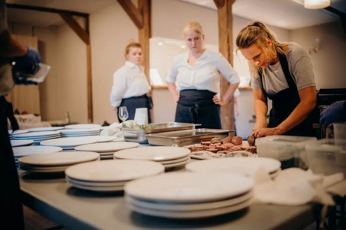 Kitchen staff plating dishes together during a service shift